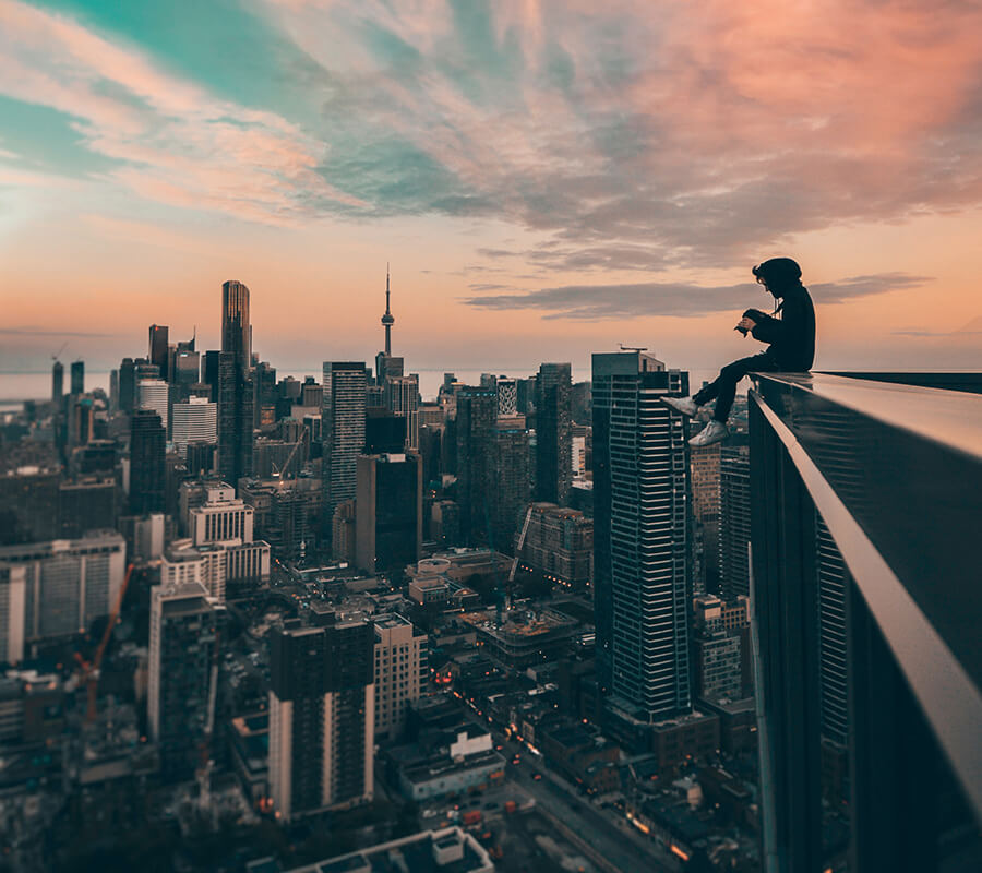 Man sitting on top of a skyscraper